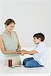 Mother and son preparing bread and jam together, smiling at each other