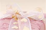 Pink gift wrapped with heart ribbon, extreme close-up