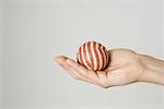 Hand holding striped ball