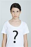 Preteen girl wearing tee-shirt printed with question mark, looking up, portrait