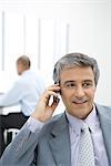 Businessman using cell phone in office