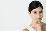 Woman looking at camera, hand under chin, close-up