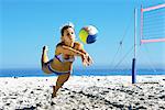 Female playing beach volleyball diving to catch ball
