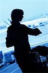 Silhouette de voyageur de femme regardant montre dans l'aéroport