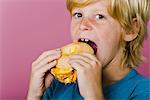 Boy eating ham and cheese sandwich