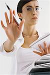 Woman with notepad, gesturing not to interrupt work