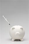 Swine flu concept with syringe inserted into piggy bank