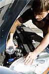 Man pouring water in radiator of overheated car