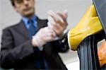 Man putting putting on disposable gloves preparing to refuel vehicle