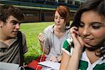 Teenage friends hanging out, girls sharing earphones, listening to music