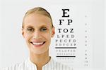 Young woman, eye chart in background, portrait