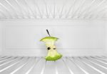Single apple core sitting on shelf inside refrigerator