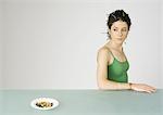 Young woman looking over shoulder at ashtray full of cigarette butts