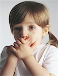 Little girl covering mouth, portrait