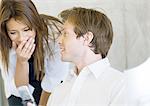 Man showing woman cell phone, woman laughing