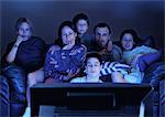 Family watching television together in the dark.