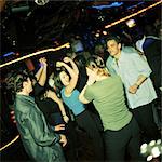 Group of young people dancing in nightclub.