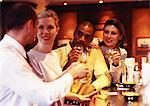 Group of business people raising glasses at bar