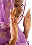 Muslim woman wearing veil holding hands up in prayer, close-up