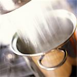 Close-up of water draining into pot on stove