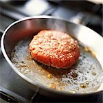 Close-up of hamburger patty cooking on pan