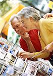 Mature woman and man looking at postcards