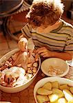 Child touching raw chicken in casserole dish