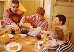 Man and children sitting at table, having breakfast