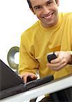 Man with laptop computer and cell phone, smiling