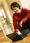 Man using laptop computer on floor