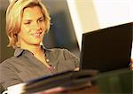Woman using laptop computer, smiling
