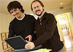 Two men with laptop computer, smiling