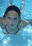 Close-up of teenage girl swimming underwater,bubbles coming out of nose