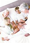 Grands-parents et enfants assis sur le lit