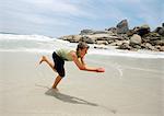 Teenage boy running on beach