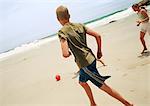 Jeunes jouant au soccer sur la plage