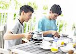 Two teenage boys having breakfast outside