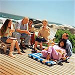 Two mature couples with children eating outside