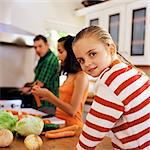Family cooking, little girl looking over shoulder
