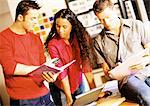 Two men and woman looking at documents