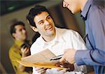 Businessmen smiling, one holding cell phone