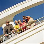 Family leaning on railing, low angle view