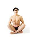 Man in underwear sitting indian style on floor with hands hovering