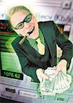 Businessman holding pile of cash, emerging from computer monitor, digital composite.