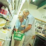 Mature couple in supermarket, man holding basket
