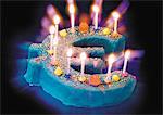Gâteau d'anniversaire signe euro avec dix bougies allumées sur le dessus.