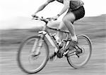 Man cycling, blurred, b&w.