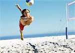 Junger Mann springen um Volleyball, Luft zu schlagen.
