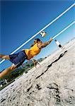 Drei junge Menschen spielen Beach-Volleyball, eine Luft.