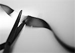 Scissors cutting ribbon, close-up, b&w.